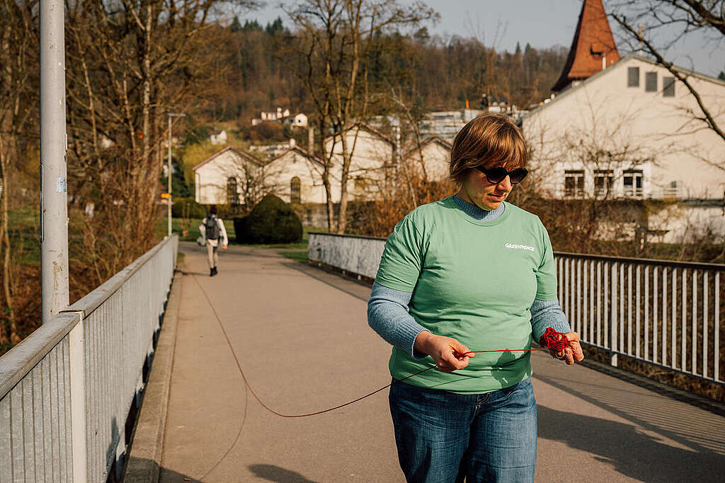 Aktion von Greenpeace-Aktivist:innen zum Thema Atomkraft: Rotes Band und roter Eisvogel als Mahnung vor möglichem Reaktorunfall und den verheerenden Folgen