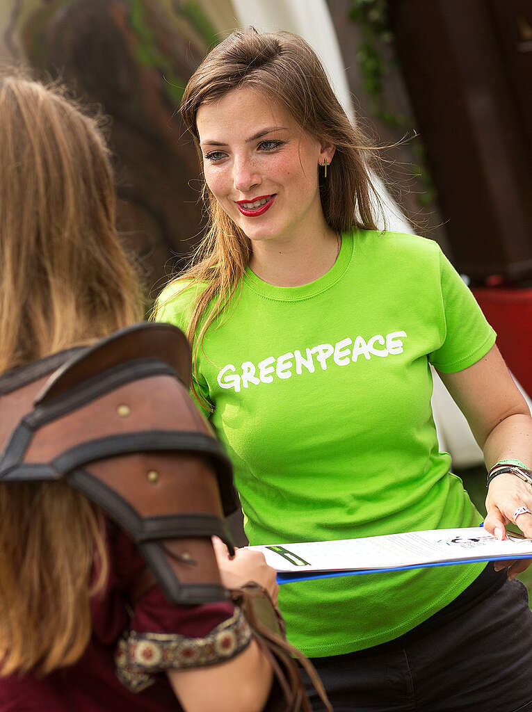 Greenpeace Volunteer Talks to Visitors at CastlefestGreenpeace vrijwilliger in gesprek met bezoekers festival de "Save the Arctic" - campagne